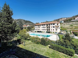 A multi-story building with a swimming pool, surrounded by greenery and hills. - Nice apartment for 3 people with pool, WIFI, TV and balcony (Pietra Ligure)