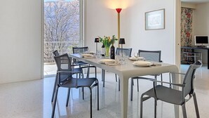 Un comedor moderno con una mesa larga, sillas y vistas al exterior.