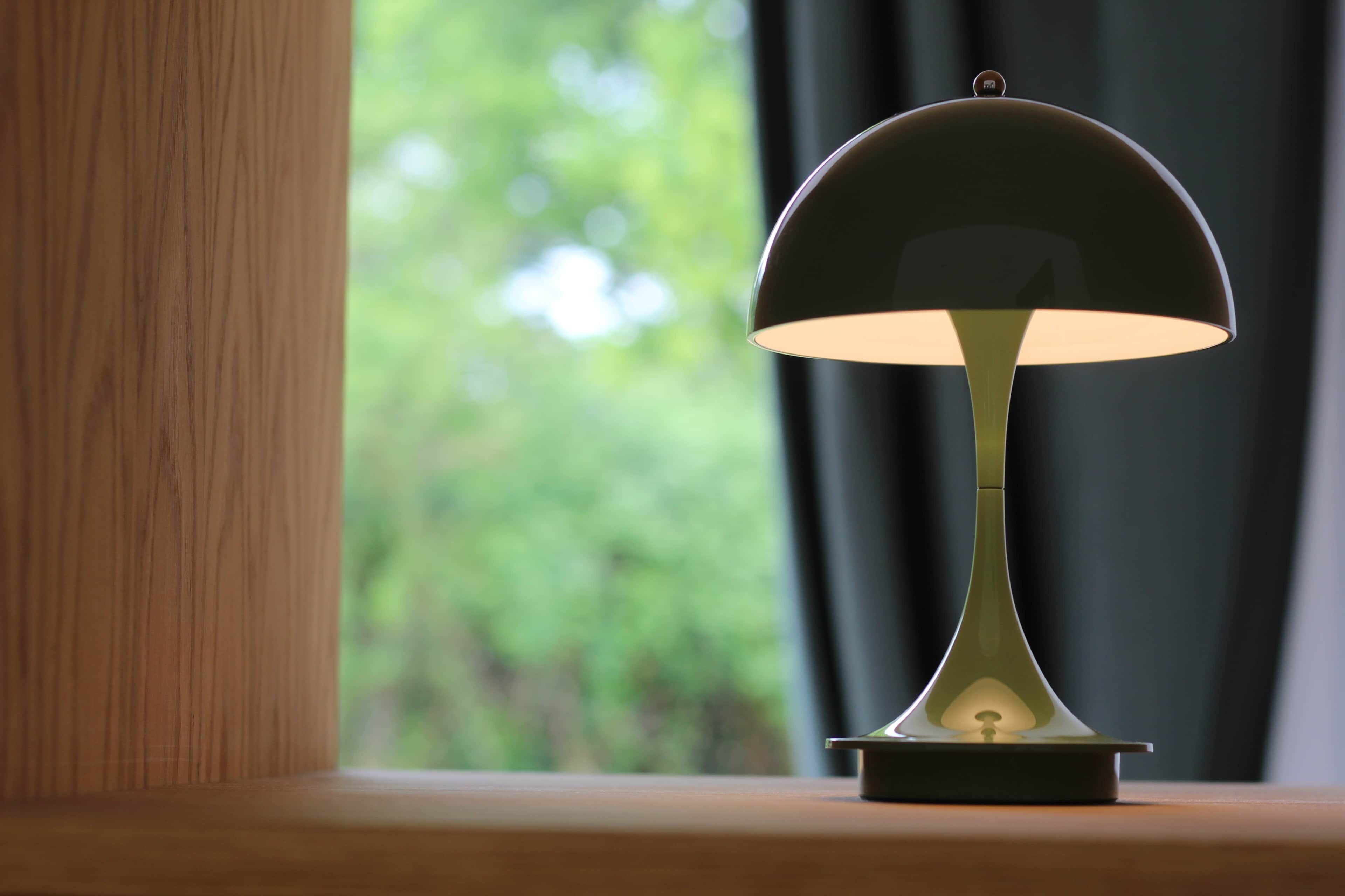 A lamp on a wooden surface with a blurred green background.