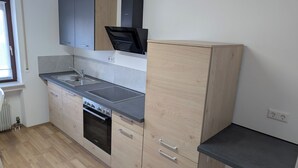 Eine moderne Küche mit Backofen, Spüle und Holzschränken.