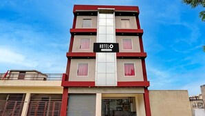 Un hotel de varios pisos con un letrero llamativo que dice 'HOTEL O & Company-Service'.