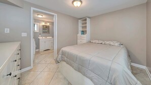 A bedroom with a bed, a dresser, a vanity with a mirror, and a walk-in closet. - Oceanview Beach Retreat (Wildwood Crest)