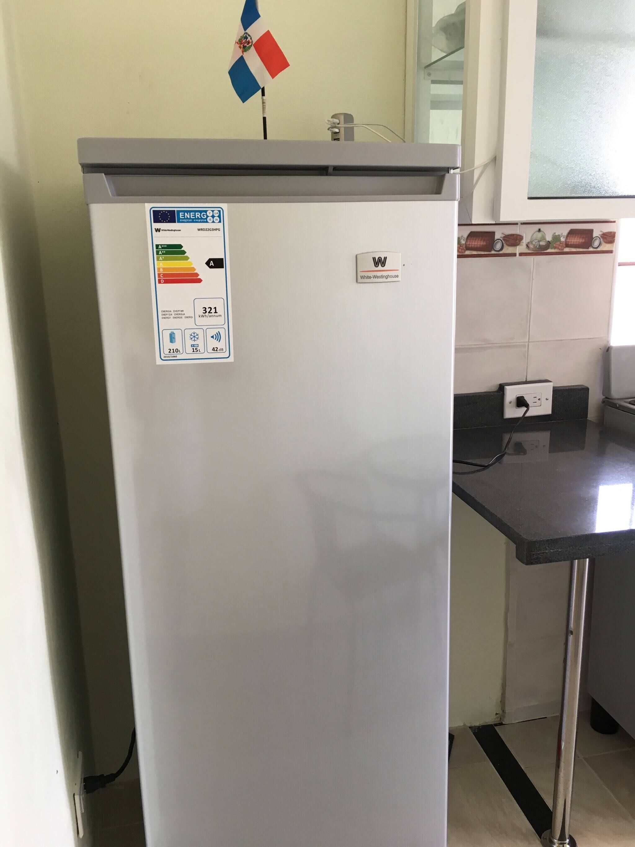 A kitchen with a refrigerator, a flag, and a White-Westinghouse logo.