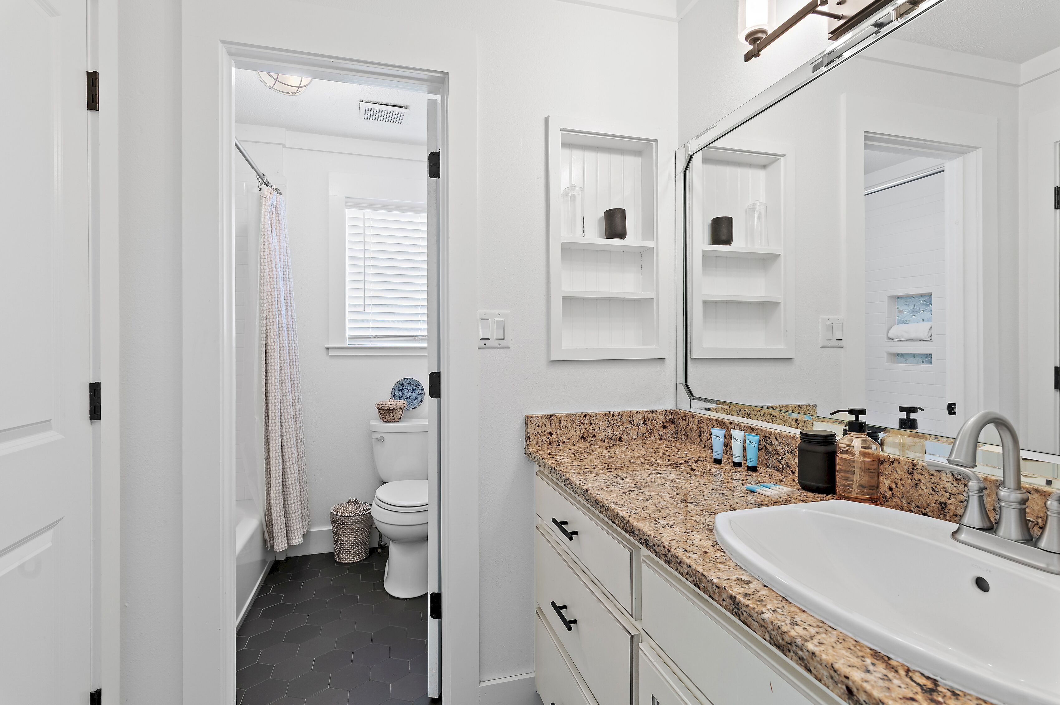 A bathroom with a white sink, a mirror, and a shower curtain.