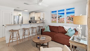 A modern kitchen with white cabinets, a stainless steel refrigerator, and a bar area with stools. - ☀️Walk to Beach | 30A | Casa Azule- Blue Mountain Beach☀️ (Santa Rosa Beach)