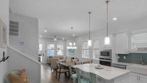 A modern kitchen with white cabinets, a central island, and pendant lighting. - ☀️Walk to Beach | 4 Bikes | Game Room | Emerald Escape 30A🏖 (Santa Rosa Beach)
