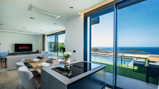 A modern kitchen with a central island, large windows, and a view of the sea. - Bovilla Hotel Sentio Yalıkavak (Bodrum)