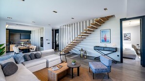 A modern living room with a staircase, a dining area, and a bedroom. - Bovilla Hotel Sentio Yalıkavak (Bodrum)