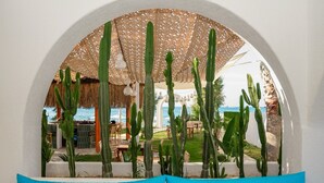 A seating area with a view of a patio and cacti, overlooking a pool and outdoor dining area. - Bovilla Hotel Sentio Yalıkavak (Bodrum)