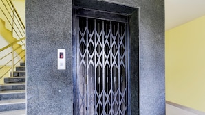 Un escalier avec une porte en métal et un écran numérique.