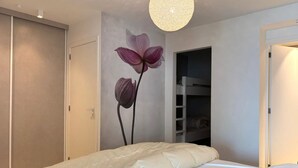 A bedroom with a bunk bed, a wall-mounted light fixture, and a door leading to another room. - Apartment With sea View in Middelkerke for 6 (Middelkerke)