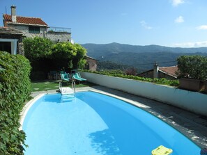A swimming pool with two slides, surrounded by greenery and a view of mountains. - Bellissimi e Paola by Interhome (Dolcedo)