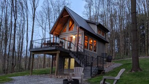 A cabin with a deck, a fireplace, and a bench. - Mohican Cabin Private Getaway (Perrysville)