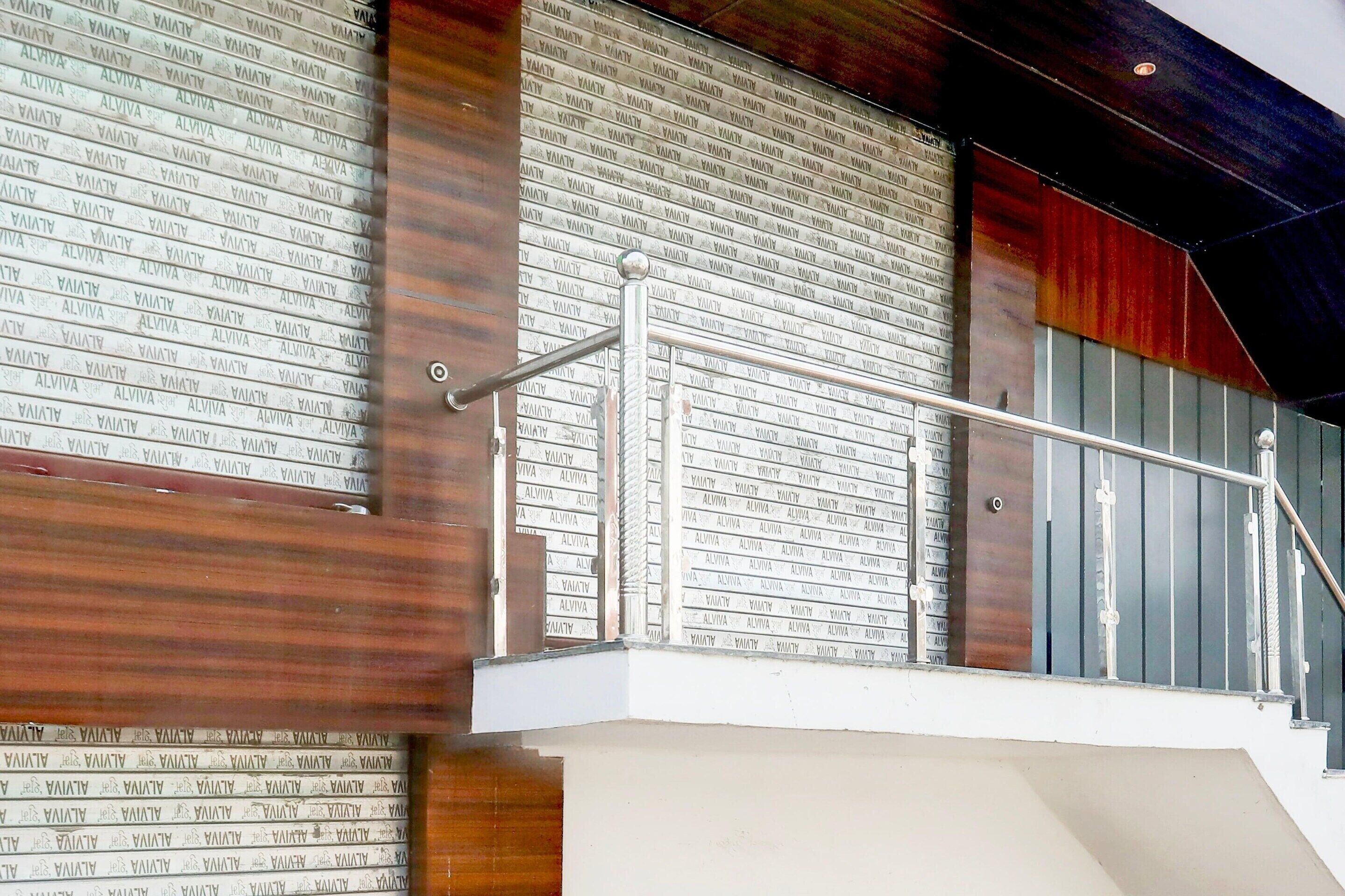 A staircase with a metal handrail and a wall with repeated text patterns.