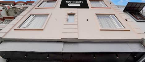 A multi-story building with a sign reading 'TOWNHOUSE Company Serviced.'