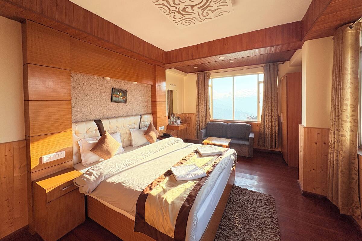Una habitación de hotel con una cama grande, un sofá, un escritorio y una ventana con vistas.