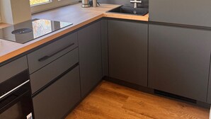 A modern kitchen with a window, built-in shelves, and a sink. - Apartment 'Design Dachgeschoss' with Shared Garden and Wi-Fi (Eilenburg)