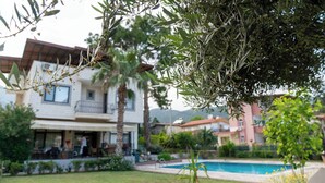 A residential building with a pool, surrounded by greenery and a clear sky. - 6 Rooms Stone Villa With Private Pool - Sea and Mountain Views (Kemer)