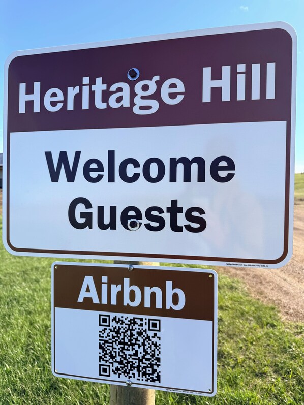 Un letrero con la leyenda 'Heritage Hill Welcome Guests' y un código QR de Airbnb.