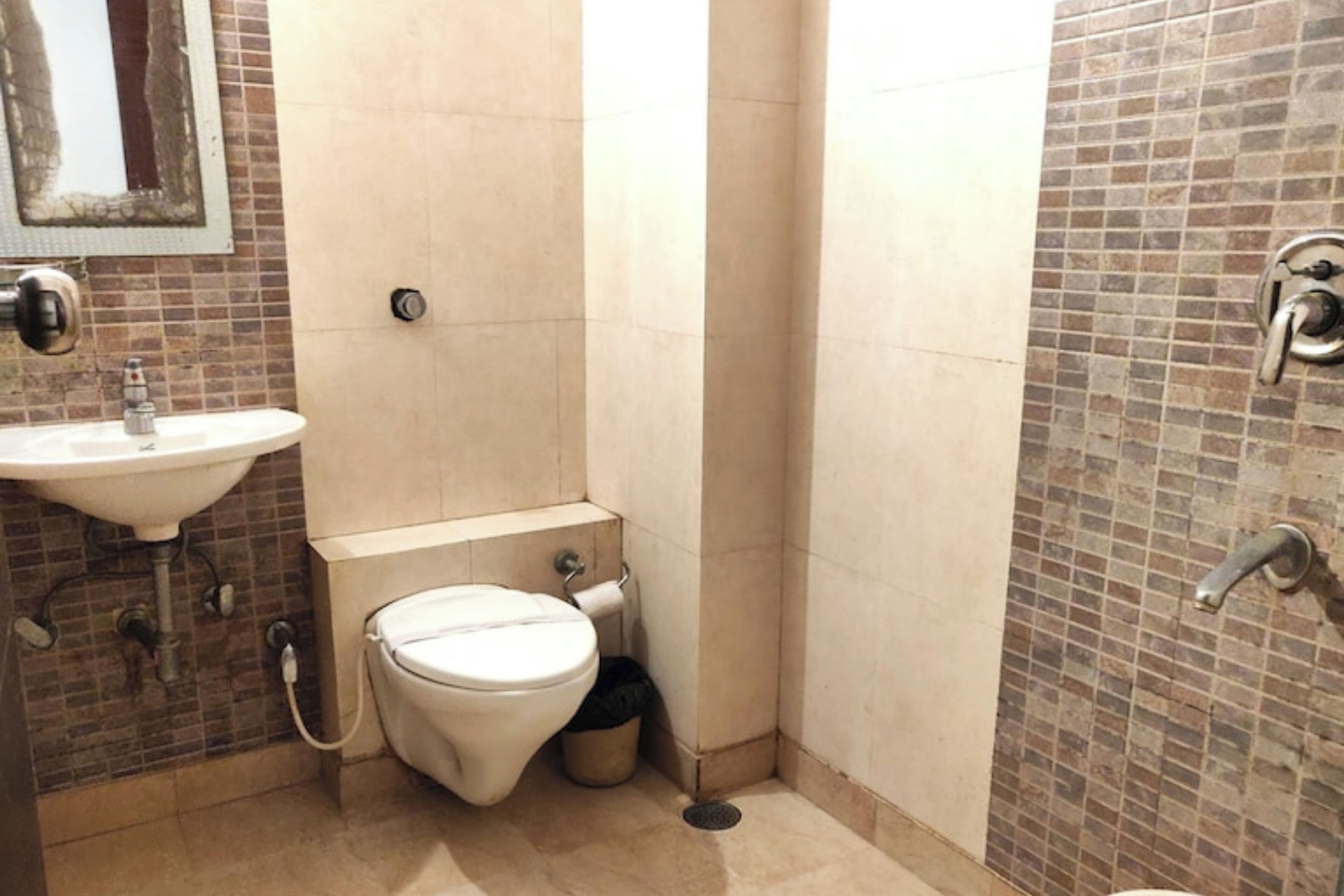 Une petite salle de bain avec des toilettes, un lavabo et une douche.