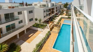 A modern building with multiple balconies, a rooftop pool, and a clear view of the surrounding area. - Penthouse with jacuzzi near the sea Campeche (Florianópolis)
