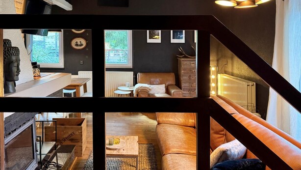 A modern interior with a staircase, a sofa, a coffee table, and a fireplace. - Cozy Durbuy Chalet With Fireplace (Rendeux)