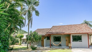 Uma casa com telhado de cerâmica, uma rede e um sinalizador.