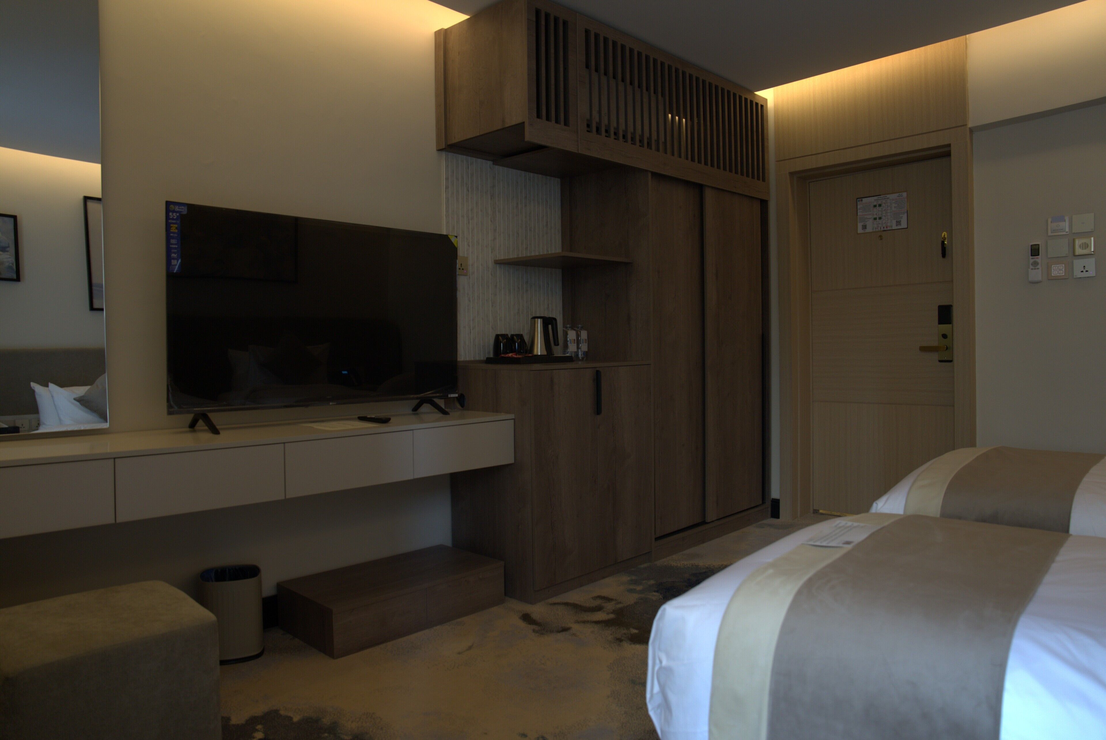 Une chambre d’hôtel équipée d’une télévision, d’une armoire, d’un lit et d’une petite table.