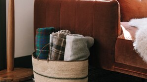 A room with a brown sofa, a floor lamp, and a woven basket on the floor. - Luxury Lakefront Cabin in Hope - Close to Camden & Rockland (Hope)