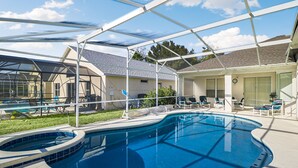 Une piscine dotée d’une structure servant de parasol, de chaises longues et d’un patio couvert.