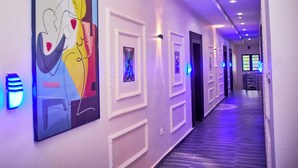 A hallway with framed artwork, recessed lighting, and a patterned floor. - Ozigrand Hotel (Benin City)