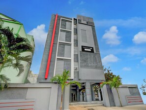 A modern building with a vertical red stripe, a sign reading 'TOWNHOUSE OAK,' and a company service logo. - Deluxeoyo Nagaram (Hyderabad)