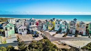 A coastal residential area with colorful houses, a beach, and a clear view of the ocean. - Oceanside 3BR | Pool + Beach Access | Ocean Views | Pet Friendly Cottage (Atlantic Beach)