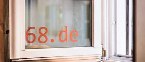 Una ventana con el texto '68.de' visible a través del cristal.