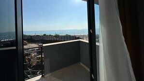 Un balcón con vista despejada al océano y a una obra en construcción.