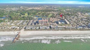 An aerial view of a coastal town with a prominent hotel, a marina, and a beach. - Tilghman Shores H1- 2 Bedroom- Short Walk To Beach (North Myrtle Beach)
