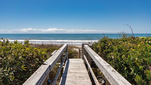 A wooden boardwalk leading to a beach with clear skies. - Oceanfront Treehouse Retreat | Private Beach Walkw (Pine Knoll Shores)