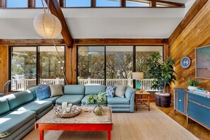 A modern living room with a sectional sofa, a coffee table, and a dining area.