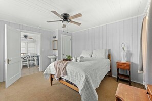 A bedroom with a bed, bedside table, and a ceiling fan. - 1 Sandy Shore- Oceanfront 6BR House- Cherry Grove (North Myrtle Beach)