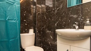 Un baño con inodoro, lavamanos y espejo.