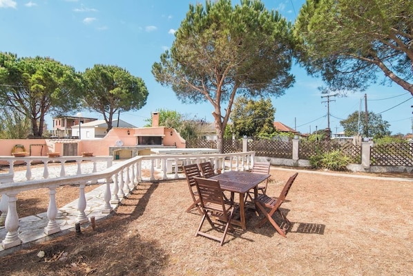 Eine Terrasse im Freien mit Tisch und Stühlen, umgeben von einer weißen Balustrade.