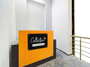 A reception desk with a sign that reads 'Collection Company Serviced.' - Deluxemedipally (Hyderabad)