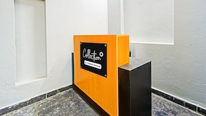 Et receptionområde med en trædisk, et sort skilt og en marmorgulv.
