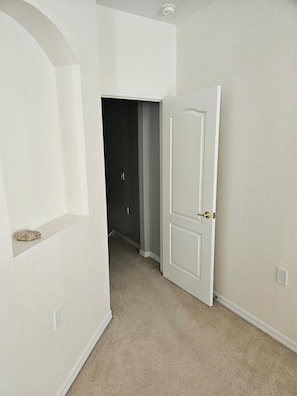 A hallway with a white door, a dark closet, and a small shelf with a book. - 3-bedrooms townhouse in lovely Verandah Fort Myers Florida (Fort Myers)