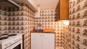 A compact kitchen with a stove, cabinets, and patterned tiles. - Southgate 3 by MPS (Agios Georgios)
