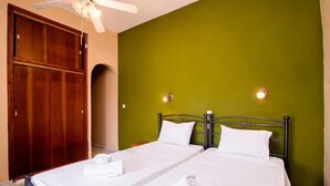 A room with two beds, a ceiling fan, and a wooden wardrobe. - Southgate 3 by MPS (Agios Georgios)