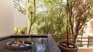 A hot tub with a breakfast tray, surrounded by trees and a potted plant. - Holistika 3BR Jungle Escape with Plunge Pool (Tulum)