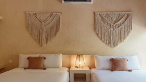 A hotel room with two beds, a nightstand with a lamp, and macramé wall hangings. - Holistika 3BR Jungle Escape with Plunge Pool (Tulum)
