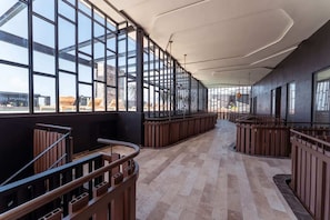 Ein modernes Interieur mit großen Fenstern, einer gewölbten Decke und einem Holzbalkon.