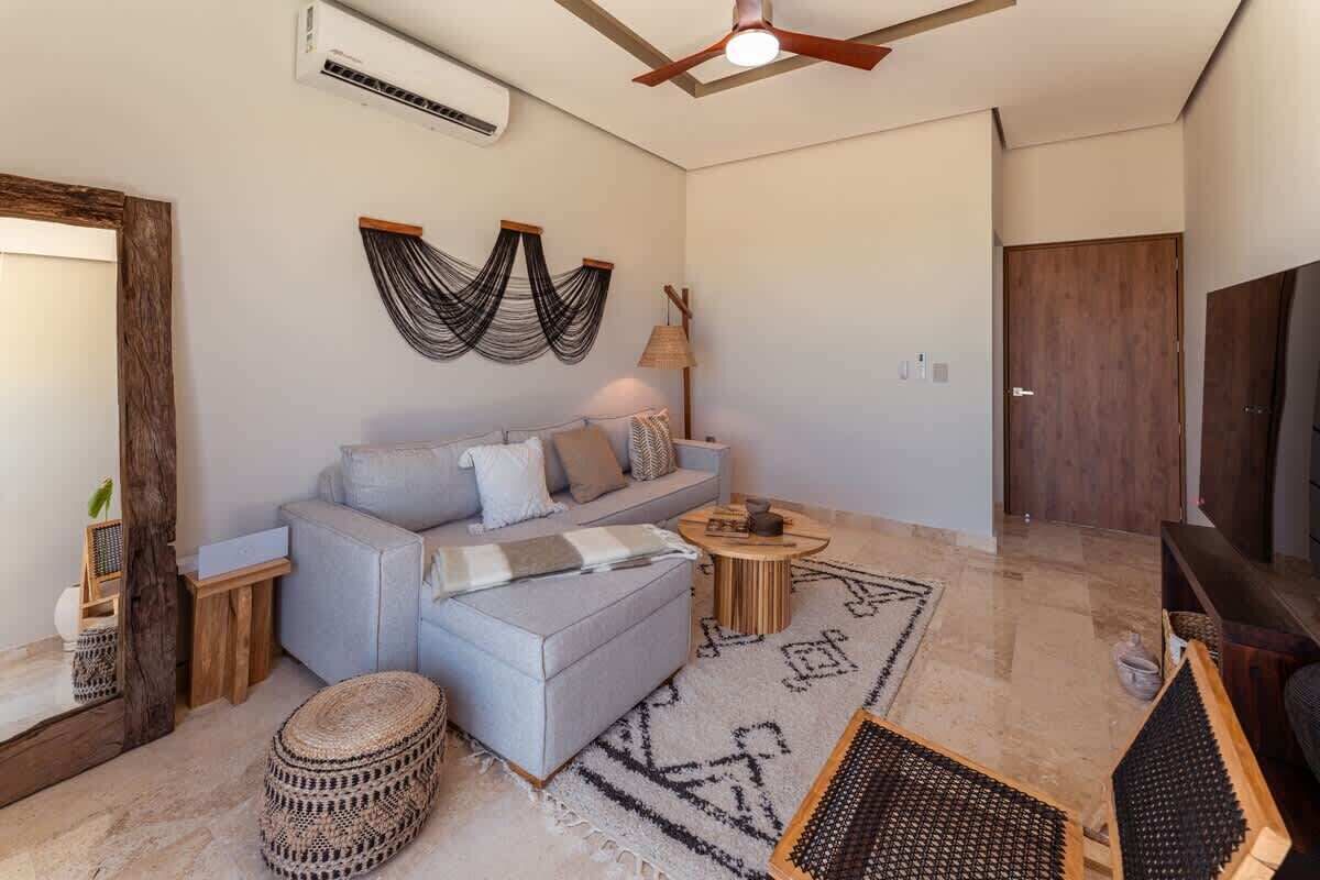 A modern living room with a sofa, coffee table, and a ceiling fan.